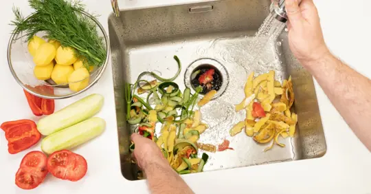 Throwing food waste in garbage disposal